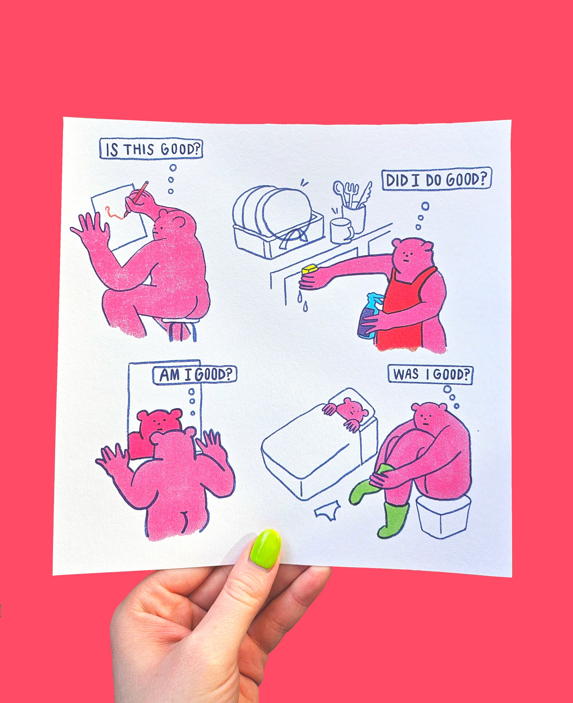 A hand holding a printed artwork with illustrations of a character in various states of indecision, titled 'Am I Good?' on a red background.