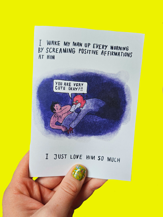 Hand holding a card with a cartoon illustration and text on a yellow background