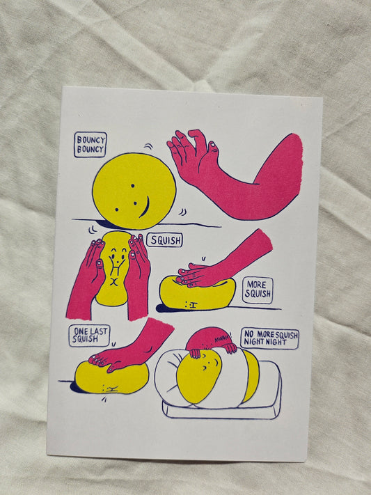 A white rectangular card featuring a comic-style illustration of yellow smiley faces and pink arms, placed on a wrinkled white fabric background.